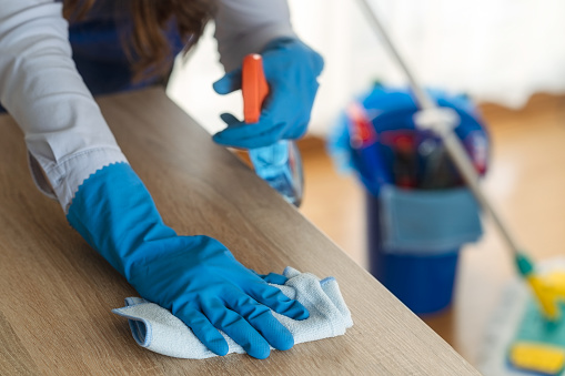 A Woman cleaning a table with a cloth